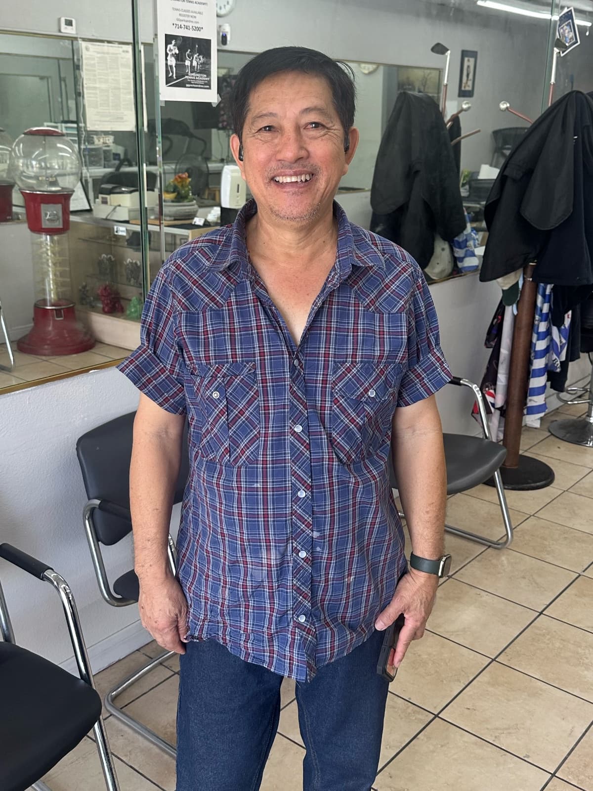 John, the barber and owner of John's Barber Shop on Knott Ave in Anaheim, standing in his shop